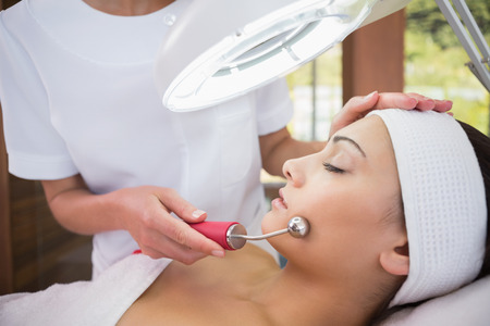 Peaceful brunette getting micro dermabrasion from beauty therapist in the health spaの写真素材