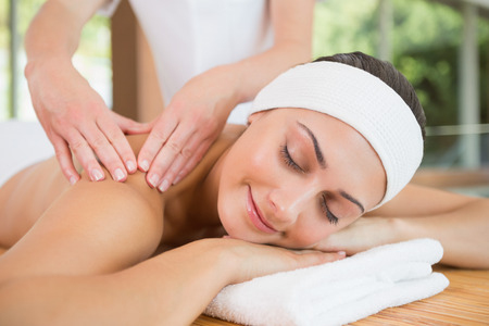 Smiling woman getting a back massage in the health spaの写真素材