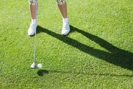 Lady golfer teeing off for the day on a sunny day at the golf courseの写真素材