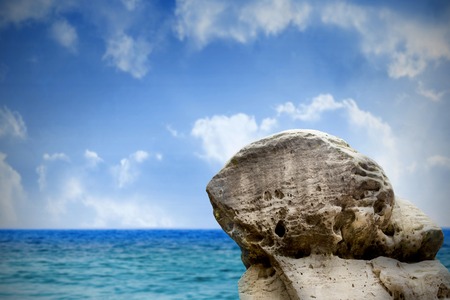 Digitally generated large rock overlooking sea and skyの写真素材