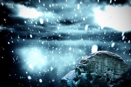 Digitally generated large rock overlooking snowy skyの写真素材