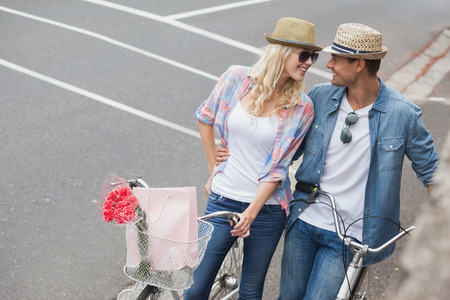 Hip young couple going for a bike ride on a sunny day in the cityの写真素材