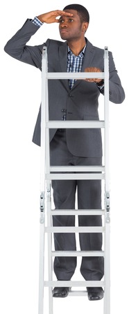 Businessman standing on ladder looking on white backgroundの写真素材