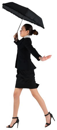 Young businesswoman holding umbrella on white backgroundの写真素材