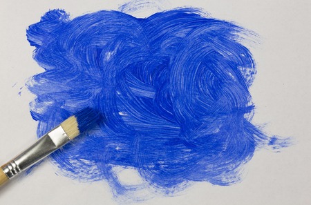 Blue paint with paintbrush on white backgroundの写真素材