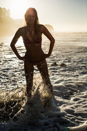 Happy blonde standing in the sea posing in bikini on a sunny dayの写真素材