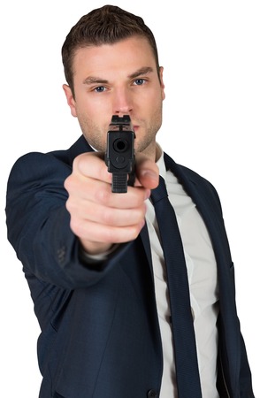 Serious businessman pointing a gun on white backgroundの写真素材