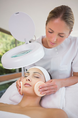 Peaceful brunette getting facial from beauty therapist in the health spaの写真素材