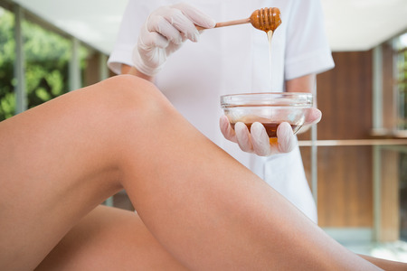 Woman getting her legs waxed by beauty therapist in the health spaの写真素材