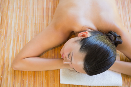 Content brunette relaxing on massage table at the health spaの写真素材