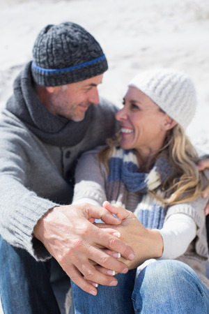 Attractive couple on the beach in warm clothing on a bright but cool dayの写真素材