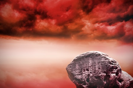 Digitally generated large rock overlooking red skyの写真素材