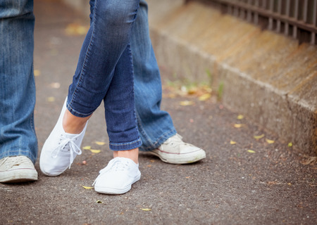 Hip young couple standing by railings on a sunny day in the cityの写真素材