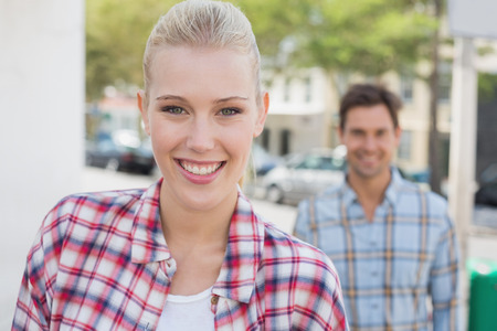 Young hip couple smiling at camera on a sunny day in the cityの写真素材