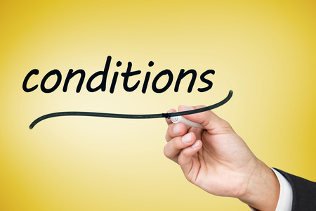 Businessman writing the word conditions against yellow vignetteの写真素材