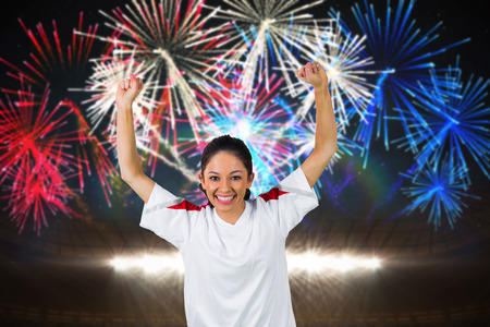 Football fan in white cheering against fireworks exploding over football stadium
