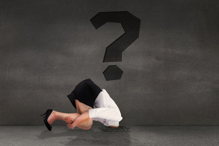 Businesswoman burying her head against punctuation in grey room