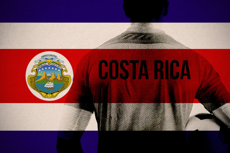 Costa rica football player holding ball against costa rica national flagの写真素材