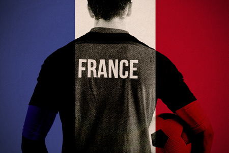 France football player holding ball against france national flagの写真素材