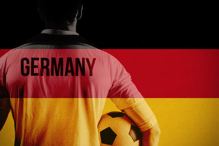 Germany football player holding ball against germany national flagの写真素材