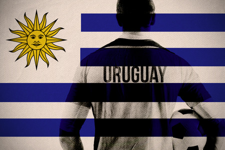 Uruguay football player holding ball against uruguay national flagの写真素材