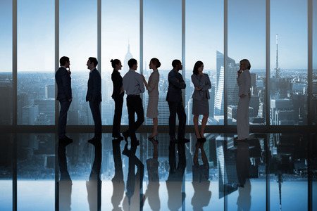 Composite image of business colleagues talking in large room overlooking cityの写真素材