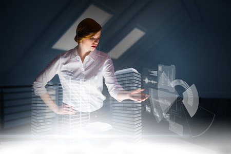 Redhead businesswoman using interactive desk against white room with floorboardsの写真素材