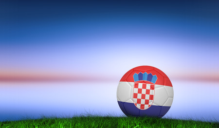 Football in croatia colours against green grass under blue and purple skyの写真素材