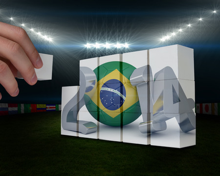 Hand building wall against football pitch with flags and lightsの写真素材