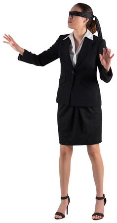 Blindfolded businesswoman with hands out on white backgroundの写真素材