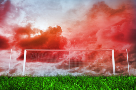 Digitally generated football goal under red cloudy sky の写真素材