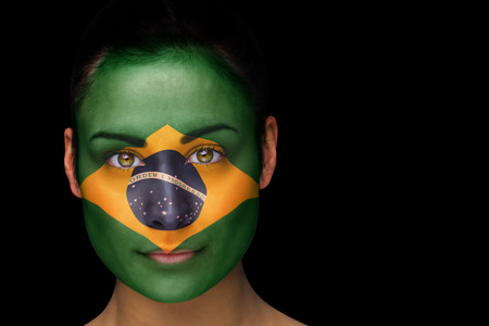 Composite image of brazil football fan in face paint against blackの写真素材