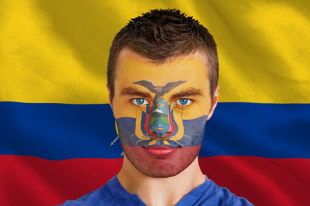Composite image of serious young ecuador fan with facepaint against digitally generated ecuador national flagの写真素材