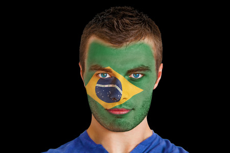 Composite image of serious young brasil fan with facepaint against blackの写真素材