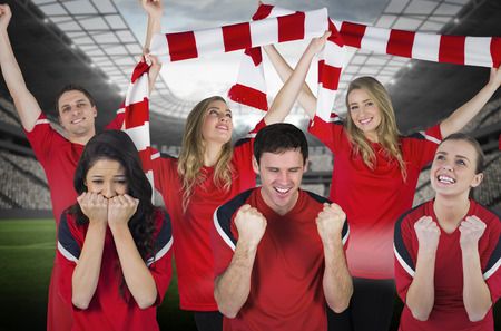Composite image of various football fans in red against vast football stadium with fans in white