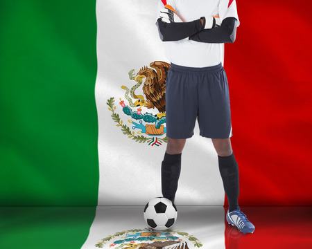 Goalkeeper in white looking at camera against digitally generated mexican national flagの写真素材