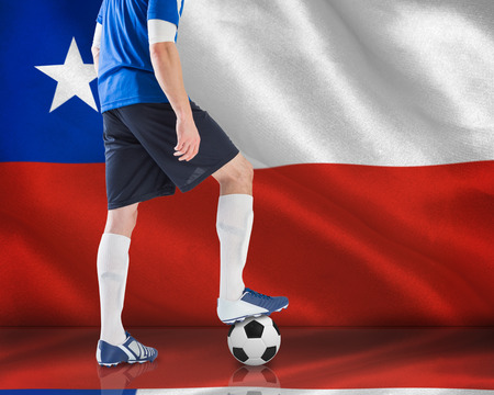 Composite image of football player standing with ball against digitally generated chile national flagの写真素材