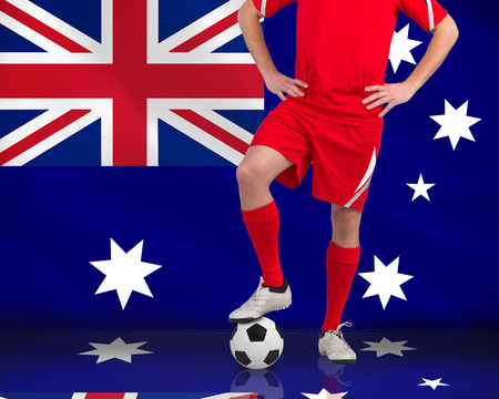 Composite image of football player standing with ball against australian flagの写真素材