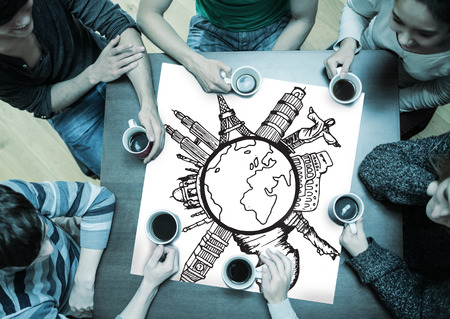 People sitting around table drinking coffee with page showing landmarks around the worldの写真素材