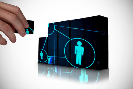 Hand building wall showing glowing connected figuresの写真素材