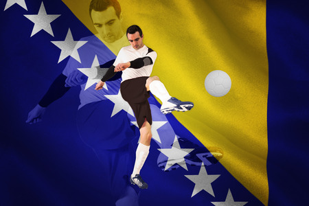 Football player in white kicking against digitally generated bosnian flagの写真素材
