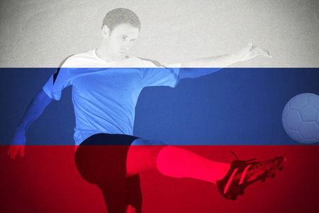 Football player in red kicking against russia national flagの写真素材