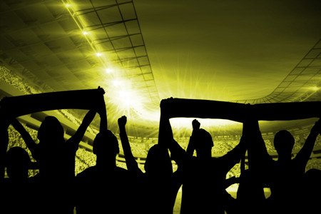 Silhouettes of football supporters against football stadiumの写真素材