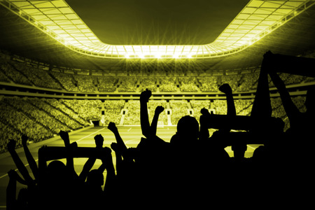 Silhouettes of football supporters against large football stadium with lightsの写真素材