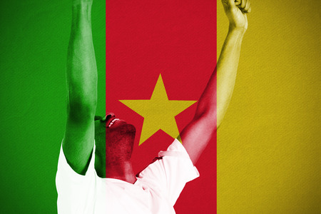Excited handsome football fan cheering against cameroon national flagの写真素材