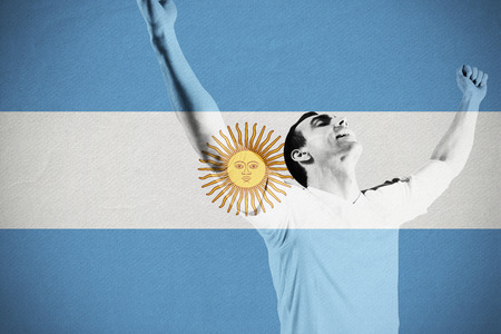 Excited football fan cheering against argentina national flagの写真素材