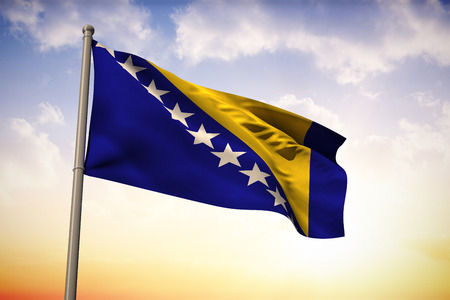 Bosnia national flag against beautiful orange and blue skyの写真素材