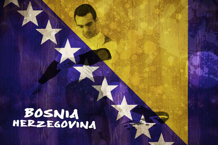 Football player in white kicking against bosnia flag in grunge effectの写真素材