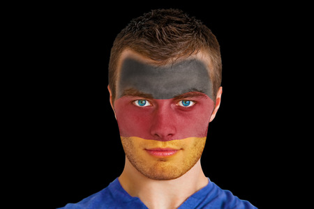 Composite image of serious young germany fan with facepaint against blackの写真素材