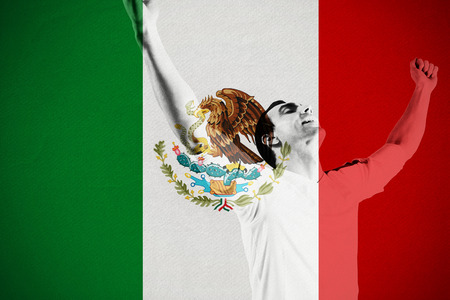 Excited football fan cheering against mexico national flagの写真素材